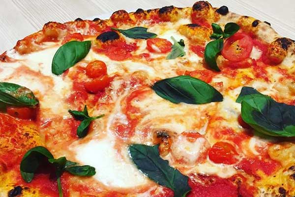 Pizza Margherita con basilico e cigliegini freschi.
